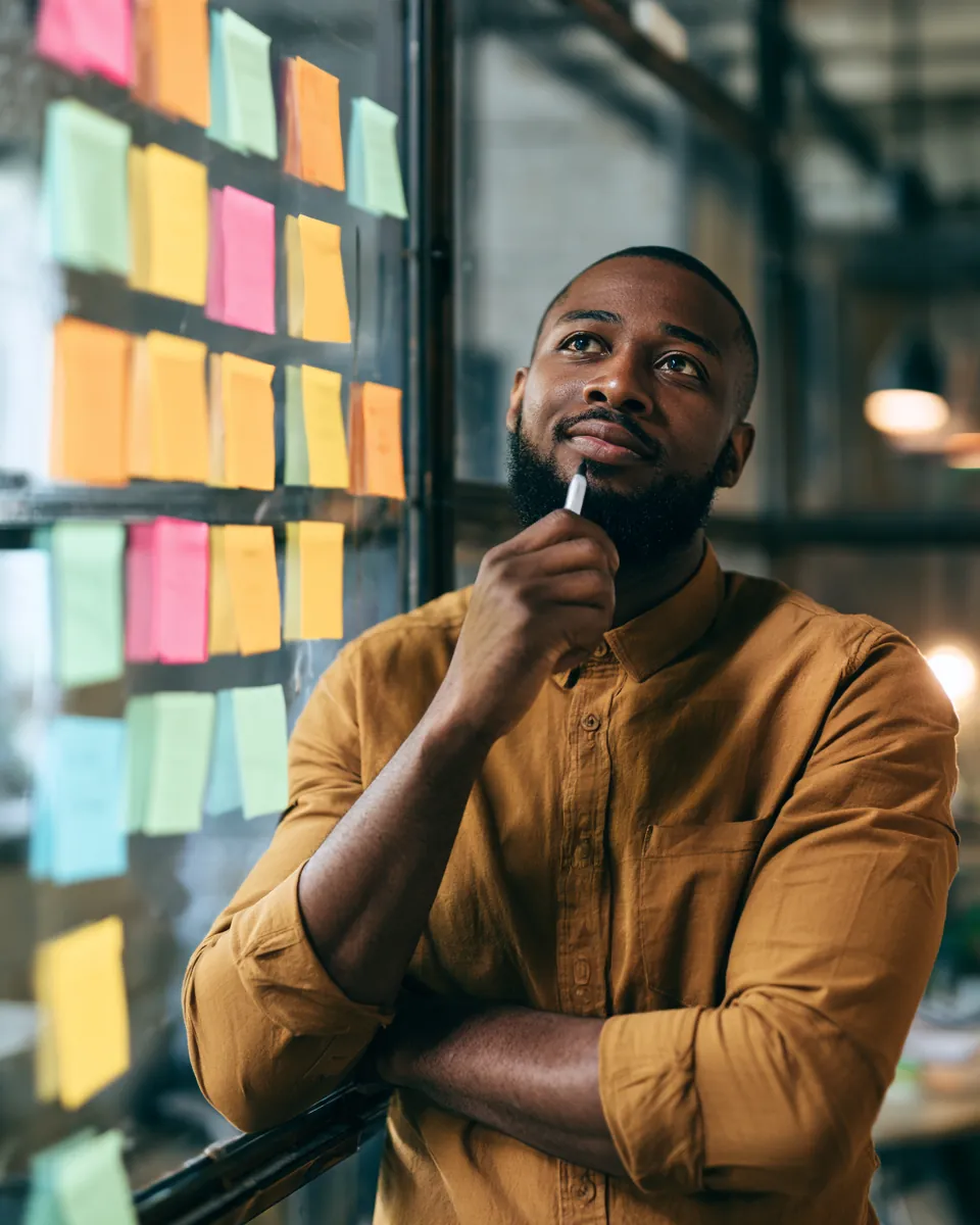 Analyst weighing options on a grid of sticky notes, comparing personal loan lenders